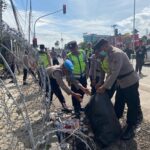 Personel kepolisian dari Polresta Pati melakukan aksi bersih-bersih di area Pengadilan Negeri Pati usai mengamankan sidang putusan terhadap Supriyono alias Botok dan Teguh Istiyanto, Kamis (5/3/2026).