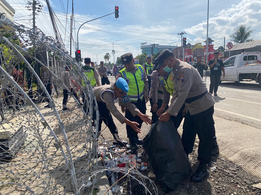 Personel kepolisian dari Polresta Pati melakukan aksi bersih-bersih di area Pengadilan Negeri Pati usai mengamankan sidang putusan terhadap Supriyono alias Botok dan Teguh Istiyanto, Kamis (5/3/2026).