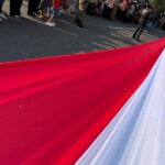 Karnaval Paskah Kota Semarang 2026 menghadirkan bentangan bendera merah putih sepanjang 100 meter yang diarak ratusan anak muda.